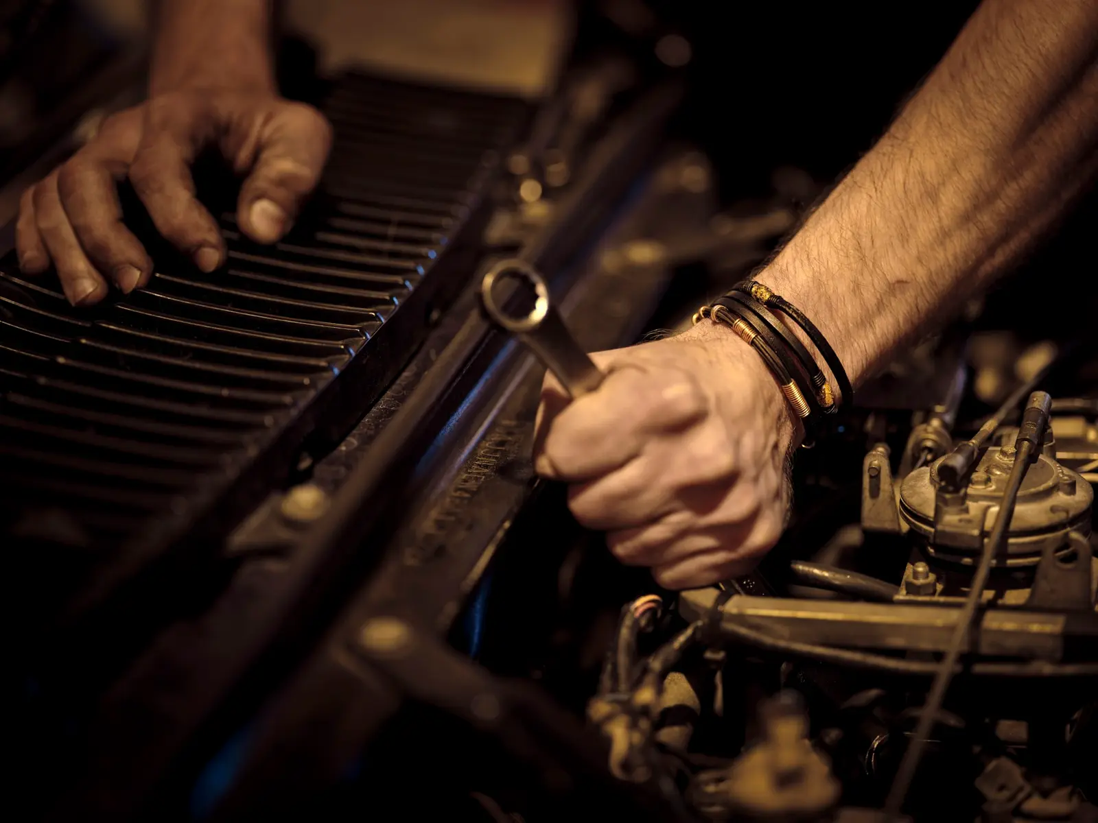 Mechanic’s hand turning a spanner on a car engine